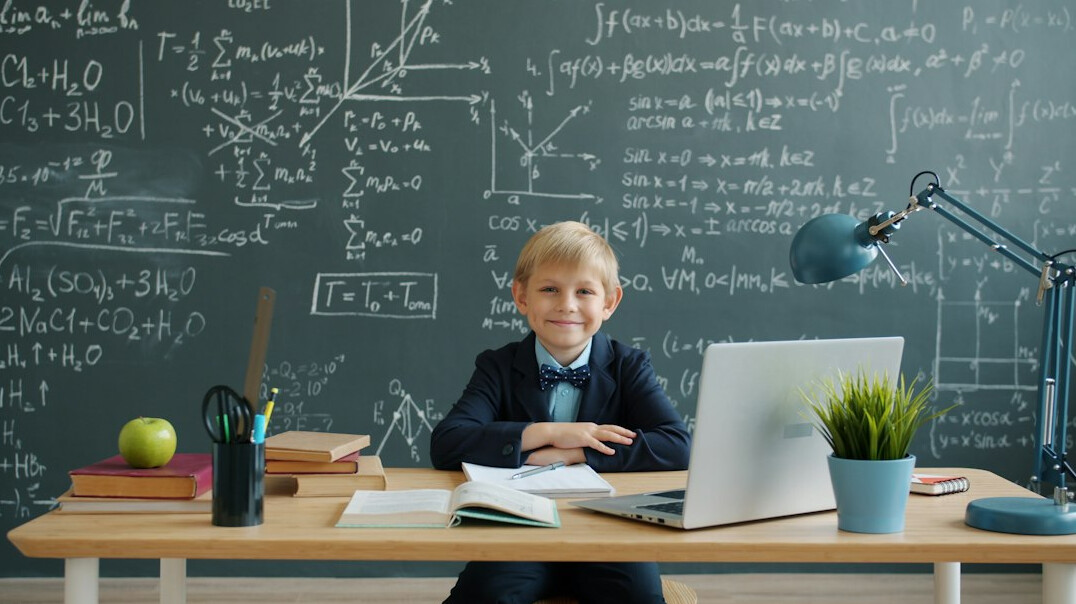 student coding on laptop in classroom