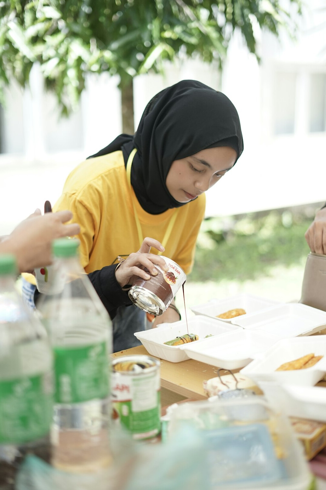 Group of young Malaysian students studying together at a table with laptops