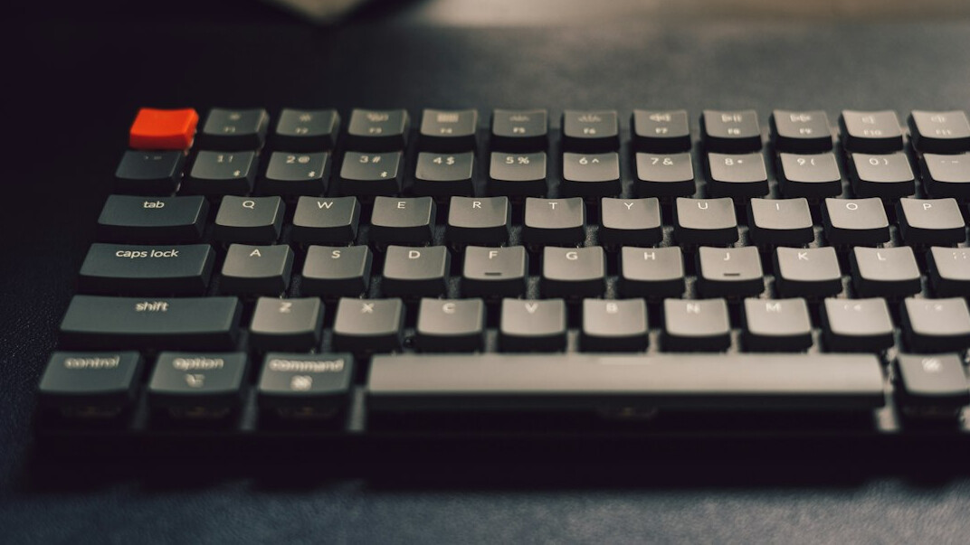 Close-up of hands typing Python code on a mechanical keyboard